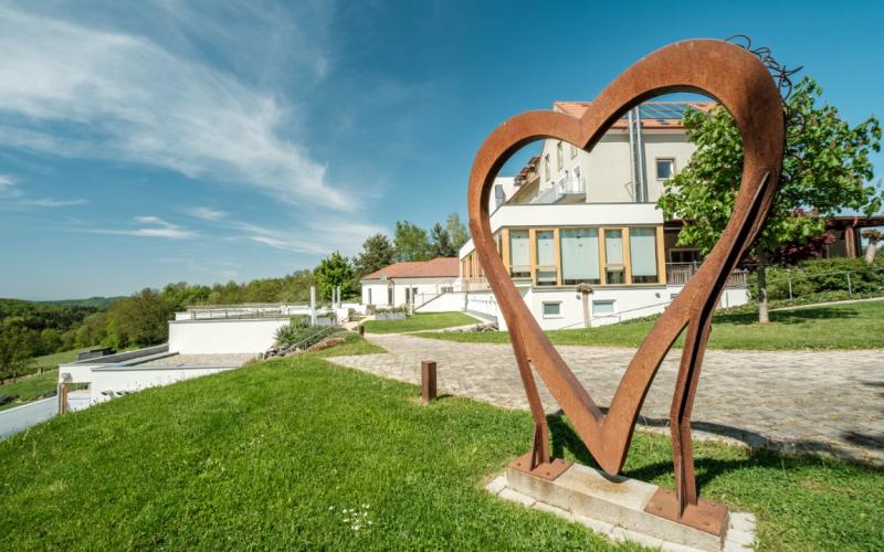 Aussenansicht mit Herz aus Metall im Das Eisenberg - Ihr Resort am Dreiländereck